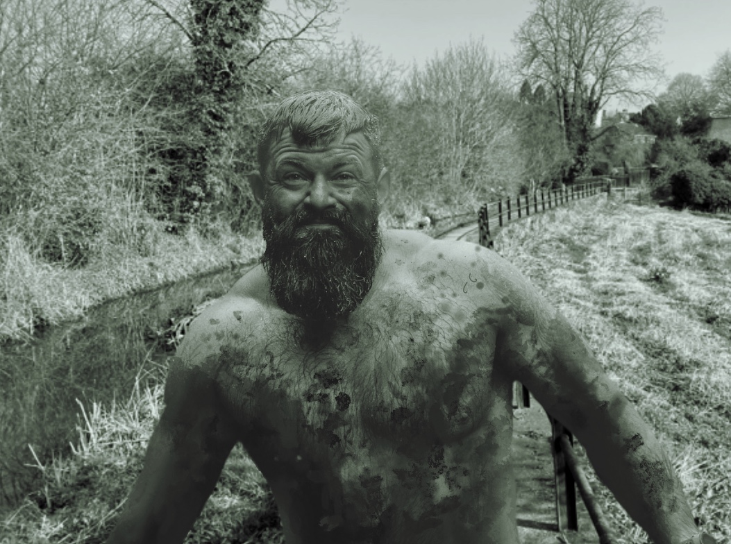 A happy, muddy farmer with no clothes on, in nature.